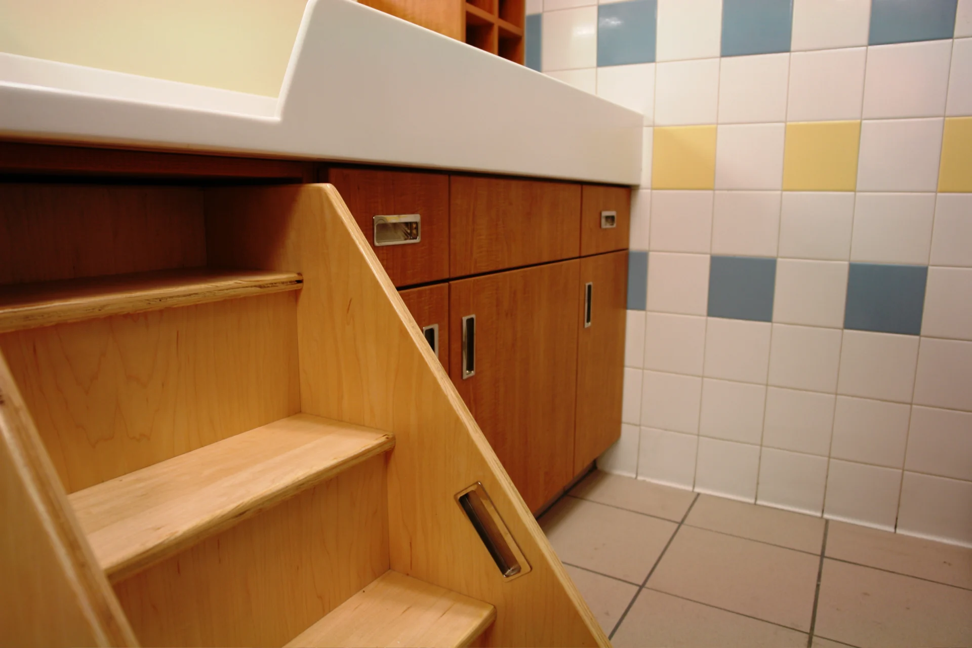 A bathroom with tiled floors and wooden cabinets.