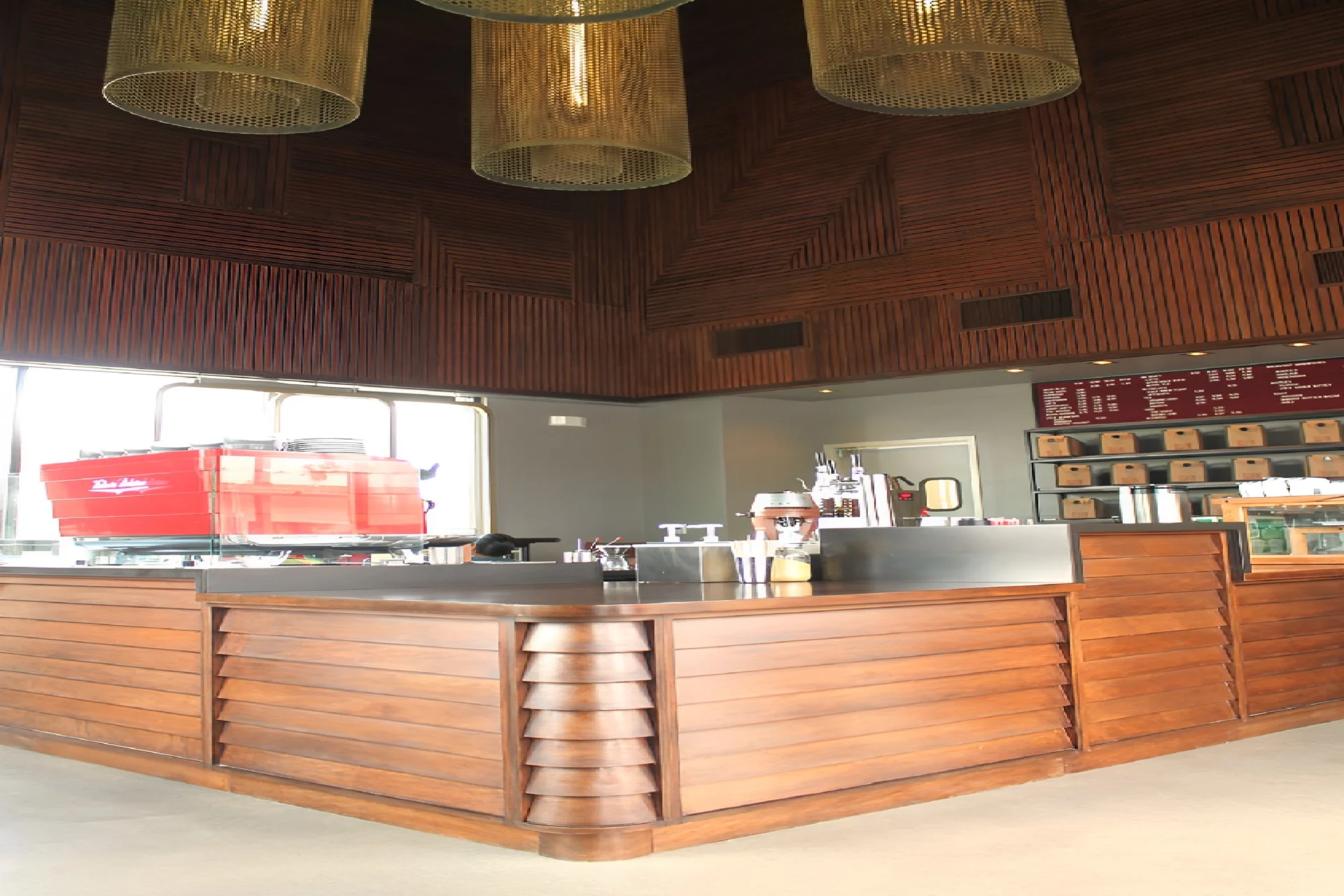 A restaurant with wooden counters and hanging lights.