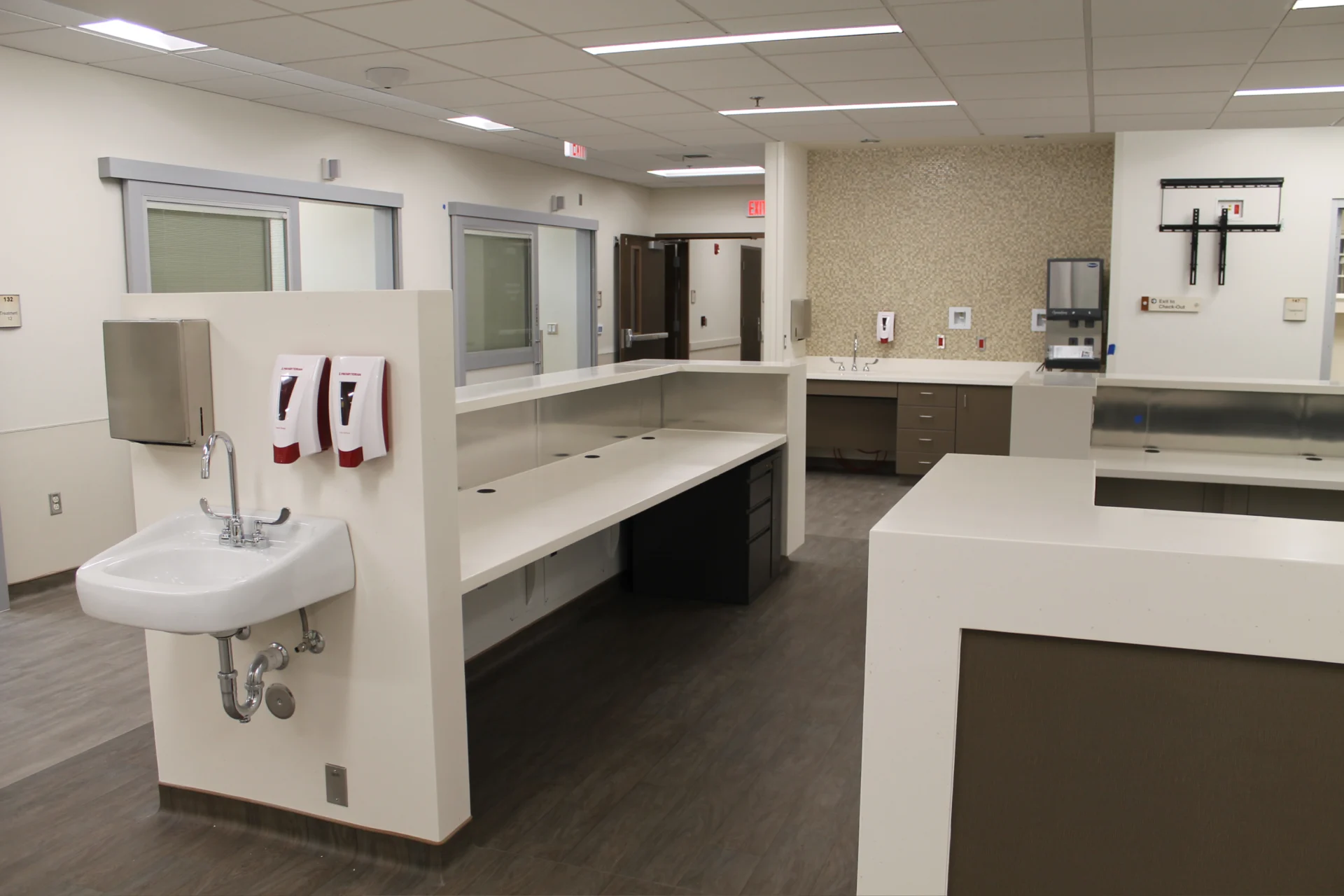 A clean office with white counters and sinks.