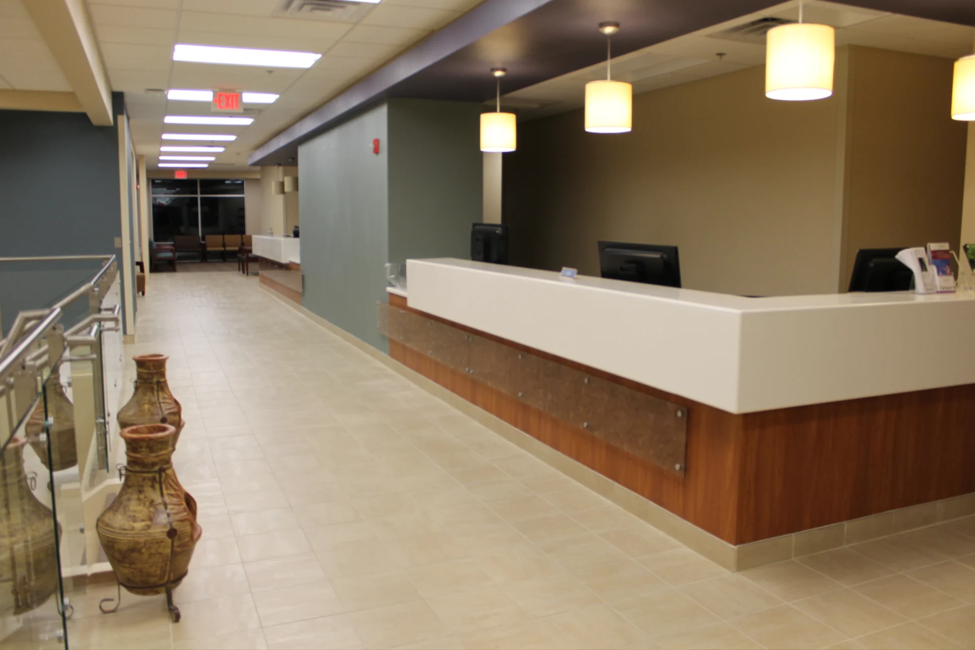 A long hallway with a reception desk and chairs.