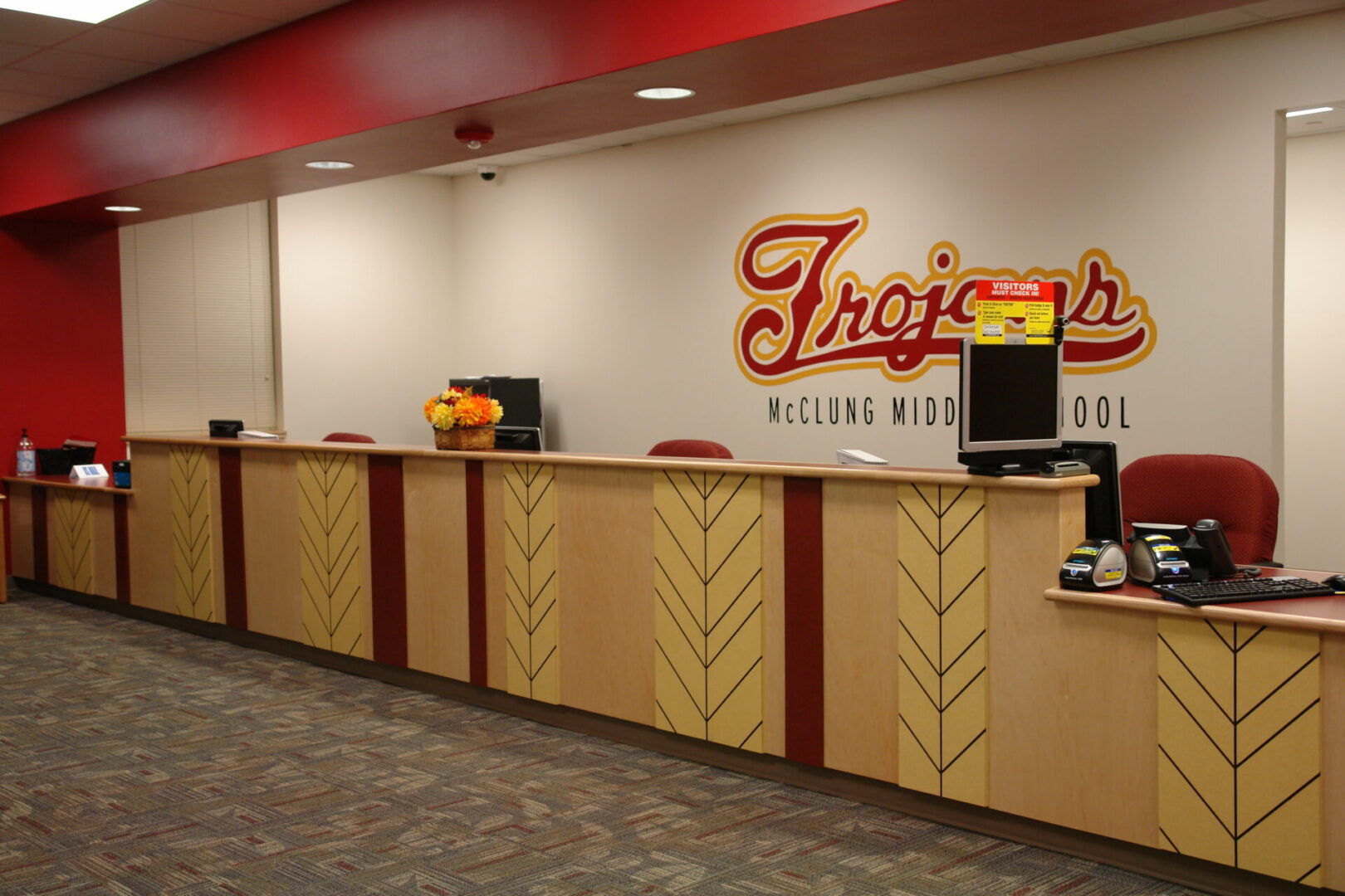 A reception desk with a large sign on the wall.