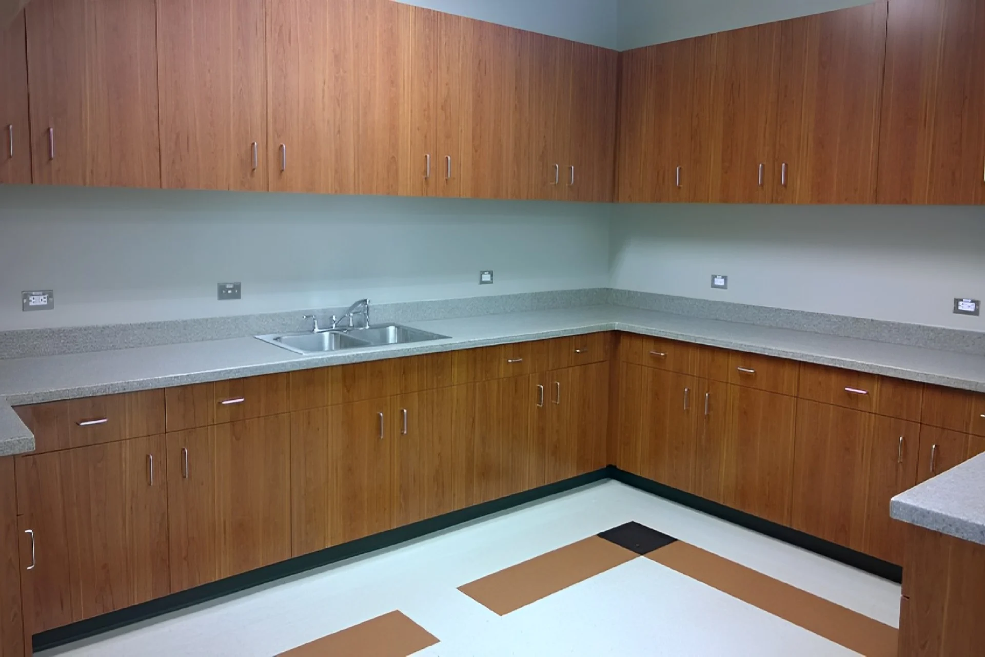 A kitchen with wooden cabinets and tile floors.