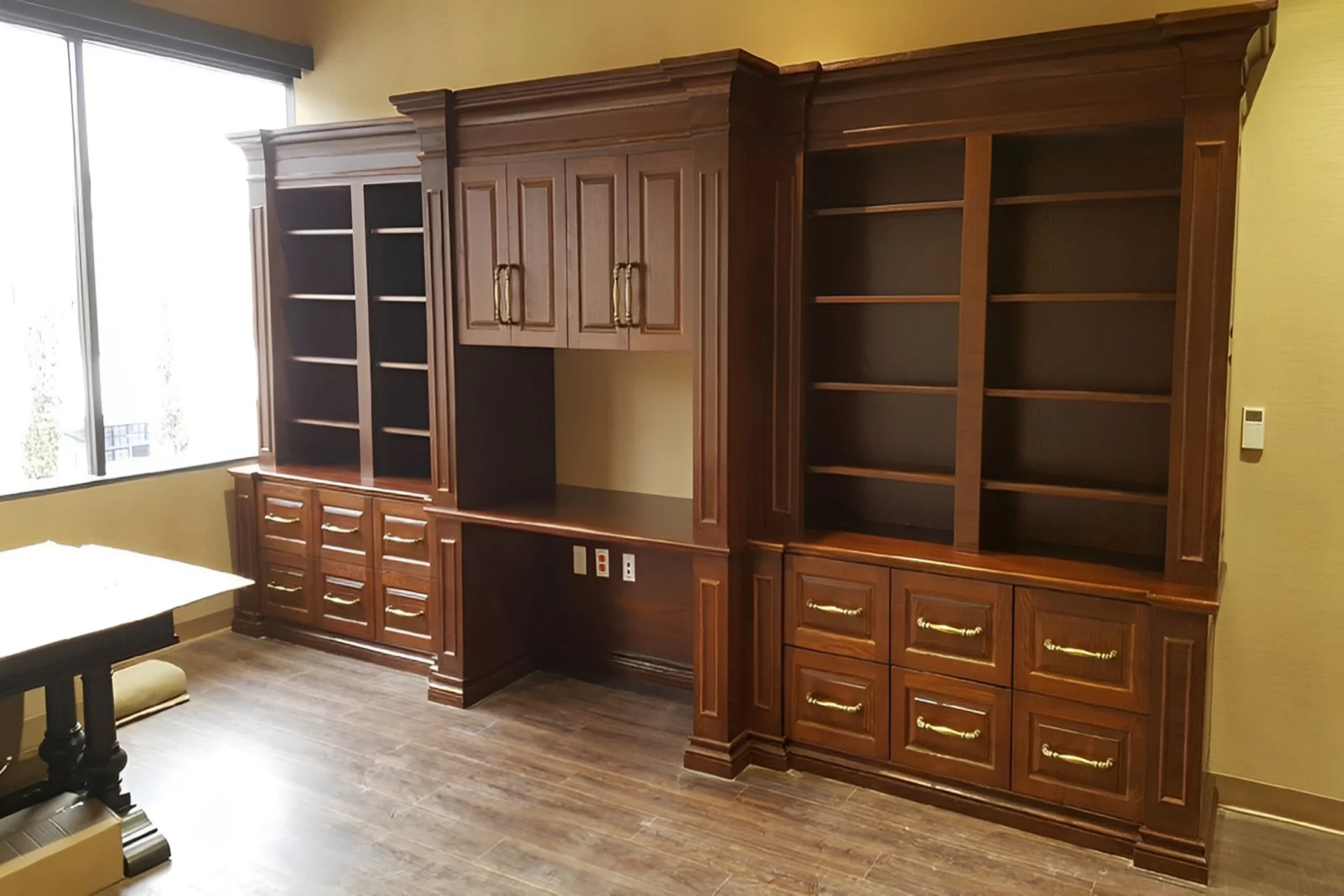 A large wooden bookcase with a desk in the middle.