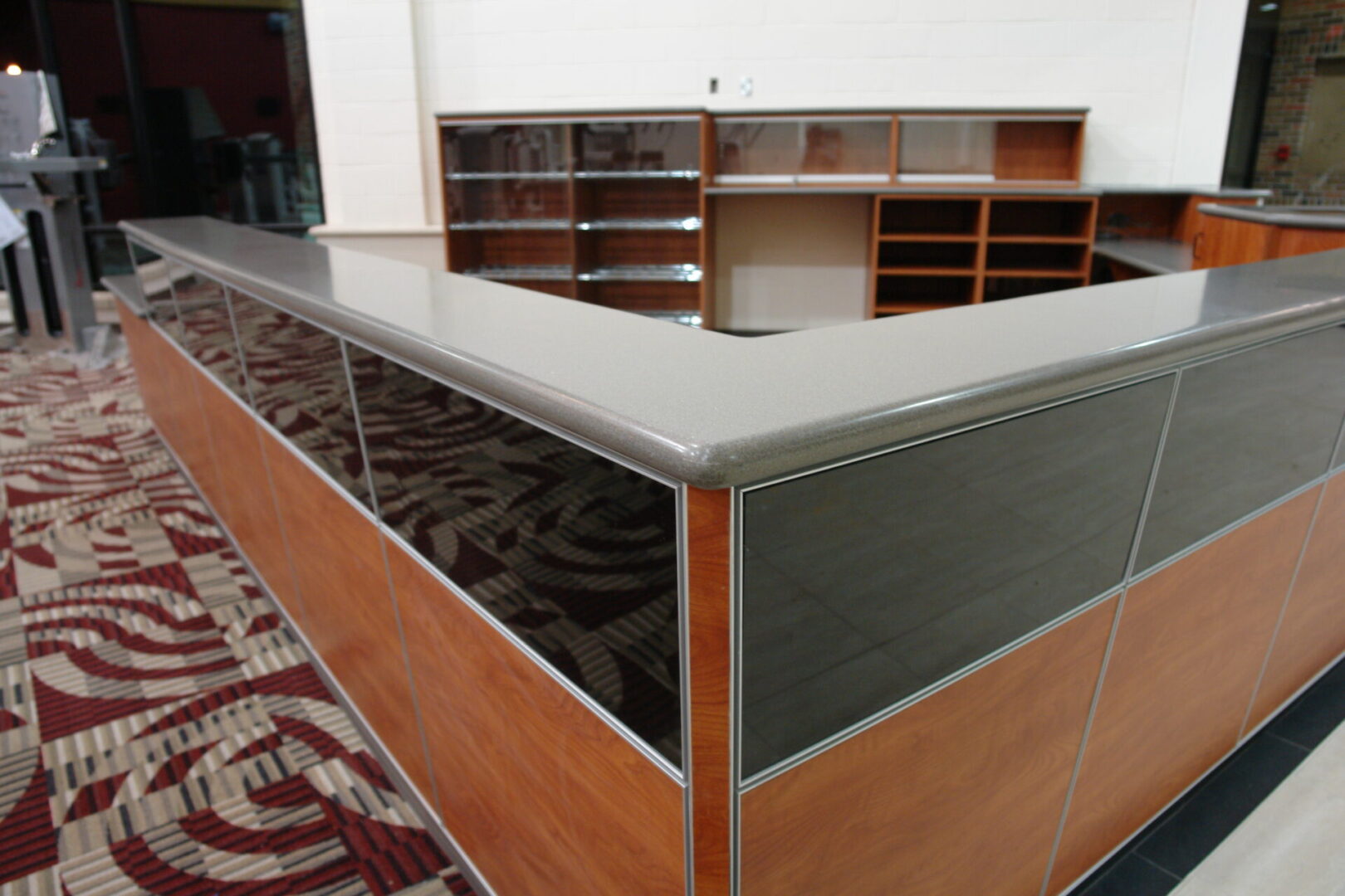 A room with a large wooden desk and some shelves.