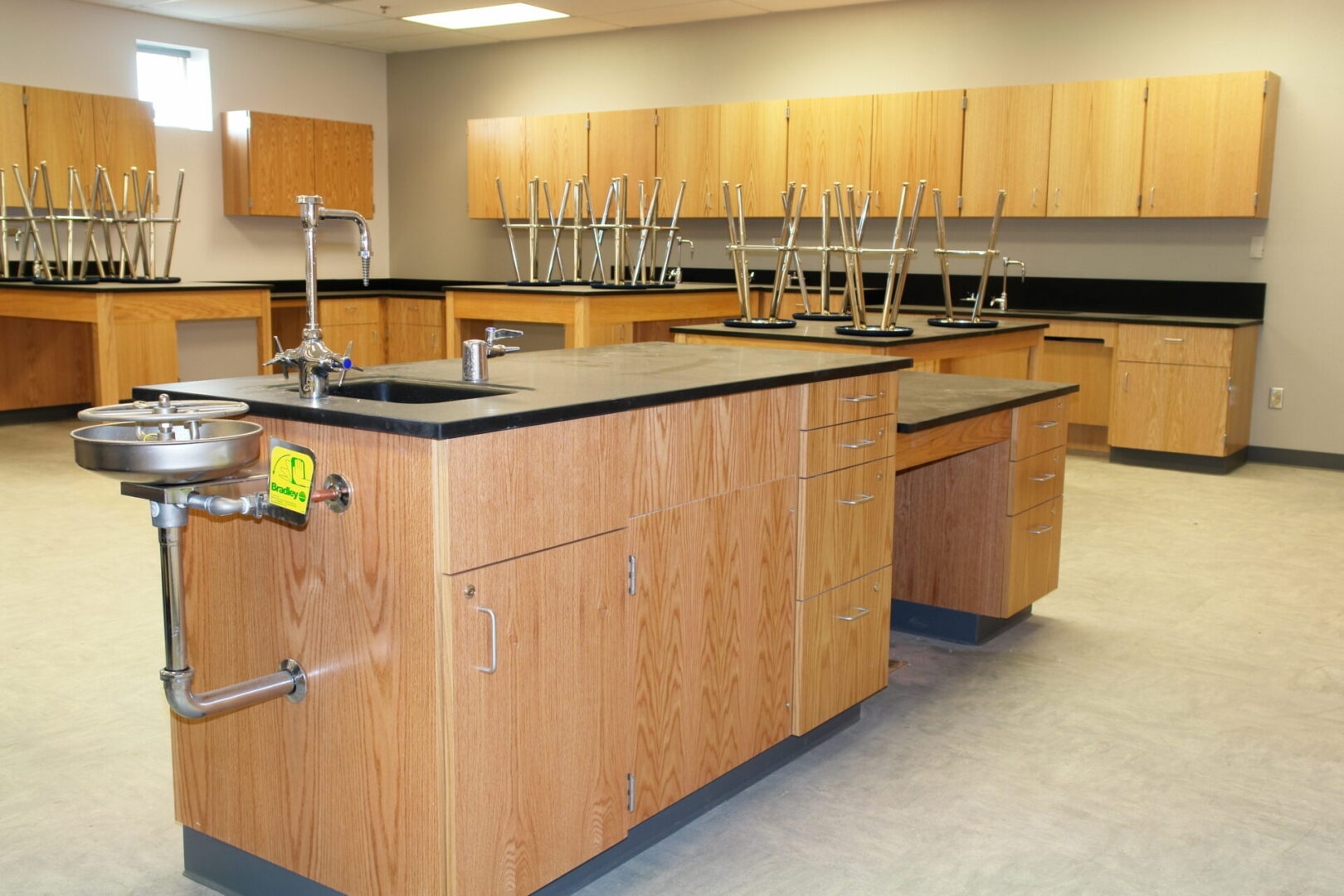 A large room with many wooden cabinets and some black tops