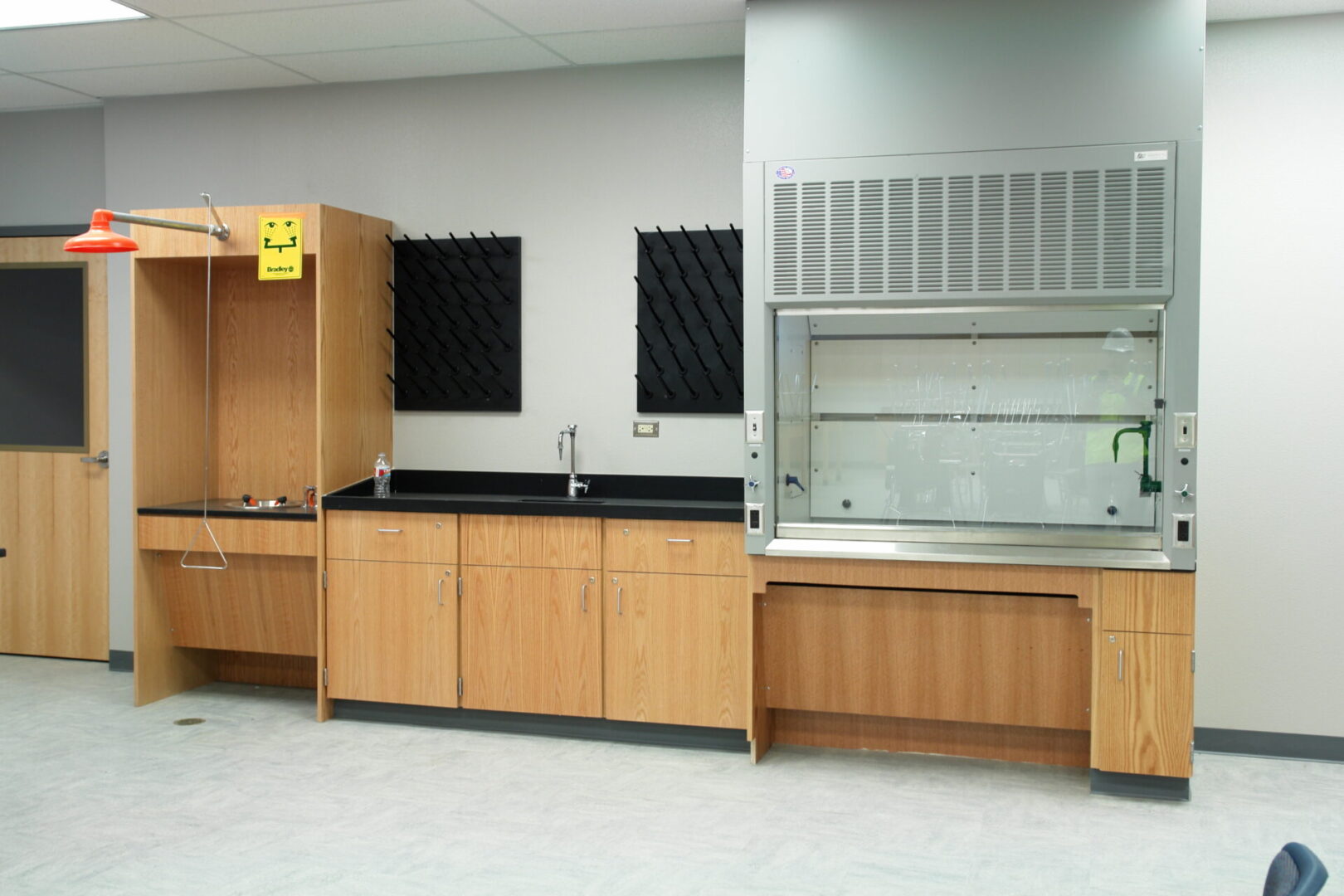 A clean room with wood cabinets and black counters.