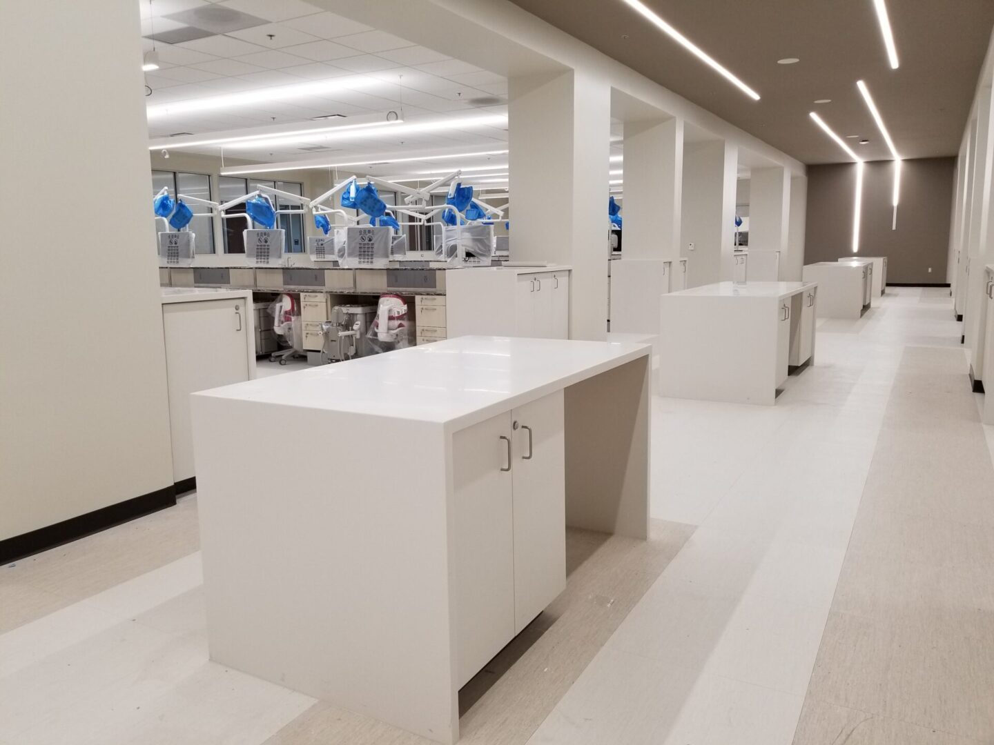 A clean room with many white counters and tables.